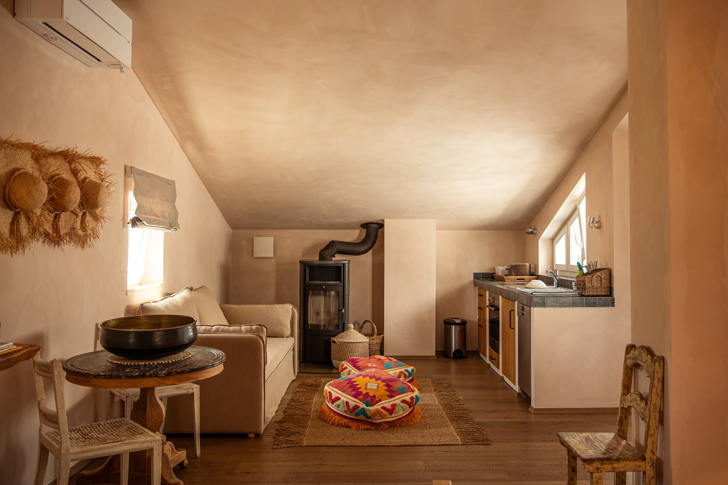 Olive Suite living area with wood burner opening to kitchenette